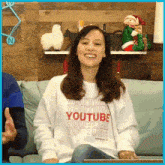 a woman wearing a white sweatshirt that says youtube