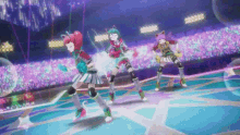three anime girls are dancing on a stage in front of a crowd of people .
