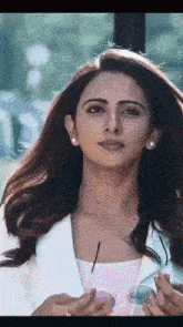 a close up of a woman 's face with a pink shirt and a white jacket