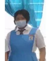 a girl wearing a blue apron and a mask is standing in front of a window .