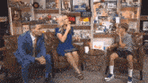 a man and a woman are sitting on a couch talking to a young boy .