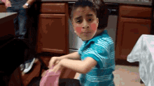 a boy with red hearts painted on his cheeks