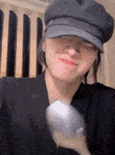 a woman wearing a hat is holding a spoon and smiling