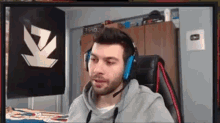 a man wearing headphones is sitting in front of a computer screen .