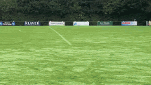 a soccer field with several advertisements including one for klaver