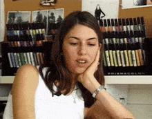 a woman is sitting in front of a prismacolor shelf