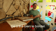 a man sits in front of a stained glass window with the words ca a ete bien le bordel on the bottom