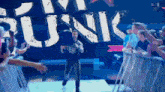 a man is walking down a stage in front of a sign that says ' junk '