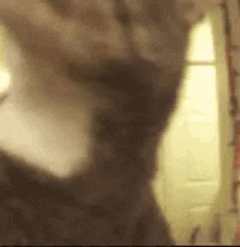 a blurry picture of a person standing in front of a mirror in a room .