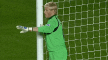a goalie wearing a green jersey that says thomas
