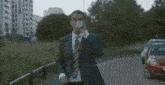 a man in a suit and tie is holding a bottle of water