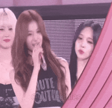 three girls are standing next to each other with one wearing a black shirt that says " oute out "