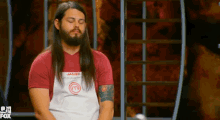 a man with long hair and a beard is wearing a white apron that says james on it