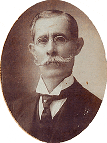 a man with glasses and a mustache is in a oval frame