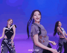 a group of women are dancing in front of a blue background and the word killpo is on the bottom