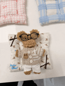 a teddy bear wearing glasses and a sweater is laying on a pillow that says papa bear
