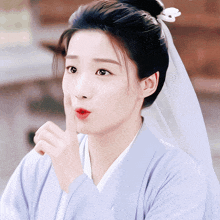 a woman with a veil on her head is making a shhh gesture