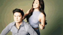 a woman is playing with a man 's hair