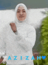 a woman wearing a hijab and a white shirt with the name azizah written on the bottom