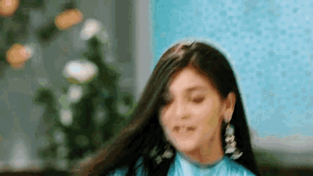 a close up of a woman wearing earrings and a blue dress .