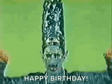 a man with a large hat on his head is holding his arms in the air and saying `` happy birthday '' .