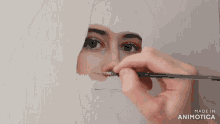 a painting of a woman 's face is being made in animotica