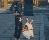 a man standing next to a white rabbit with red eyes and a bell around its neck