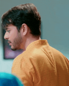 a close up of a man 's back with a yellow shirt