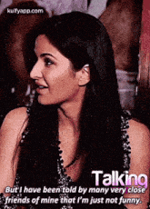 a woman is talking to a group of people while sitting in a room .