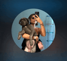a woman is taking a selfie with her dog in her arms