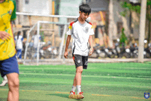 a soccer player with the number 10 on his shorts stands on a field