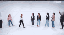 a group of women are standing in a row in front of a kbs world sign