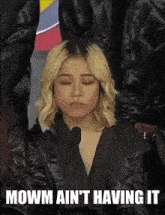 a woman in a black jacket says " mowm ain 't having it " with her eyes closed