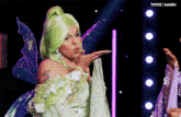 a woman in a fairy costume blowing a kiss on a stage
