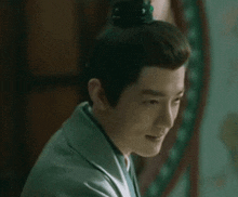 a man with a crown on his head is smiling and looking at the camera .