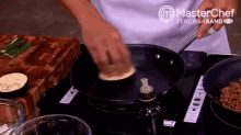a person is cooking on a stove with a master chef logo on the bottom