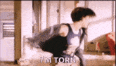 a man is dancing in a room with the words `` i 'm torn '' written next to him .