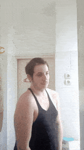 a shirtless man stands in front of a bathroom mirror