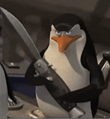 a penguin is holding a knife in its hand