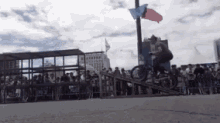 a man is riding a bike down a ramp in front of a crowd .