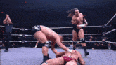 a wrestling match is going on in a ring with a referee in the background