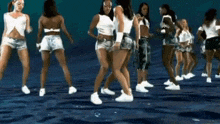 a group of young women are dancing in a pool of water .