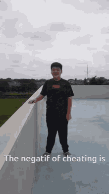 a young man standing on a balcony with the words the negatif of cheating is written below him