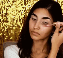 a woman is applying a dropper to her face