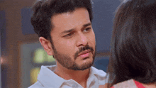 a man with a beard is looking at a woman with a tear running down his face