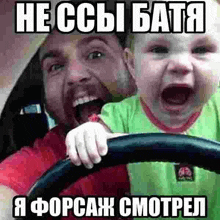 a man is driving a car while holding a crying baby in his lap .