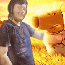 a man in a blue shirt is standing next to an orange cartoon character