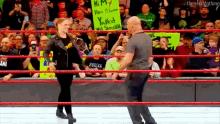 a man and a woman are standing in a wrestling ring with a sign that says hi my new home