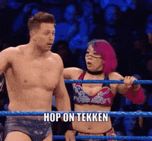 a man and a woman are standing in a wrestling ring .