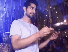 a man in a white shirt is holding a glass in his hands